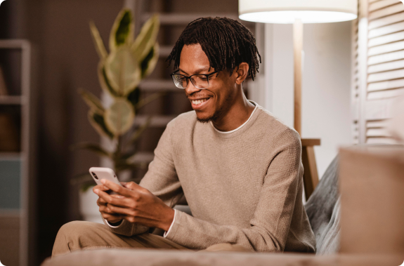 homem mexendo em seu celular e sorrindo